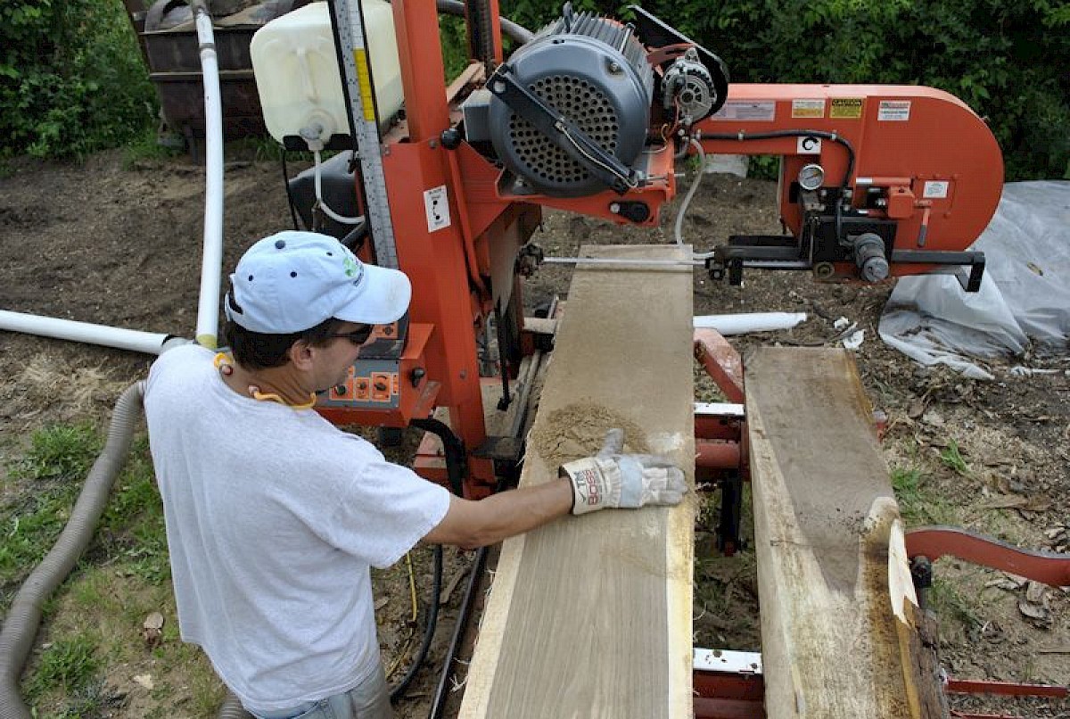John sawmilling a large log on the band mill